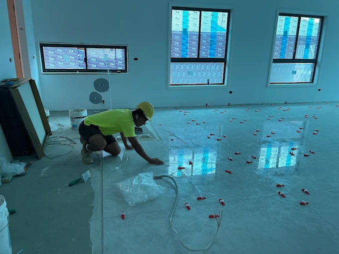 Tiler laying large-format porcelain tiles on a residential floor